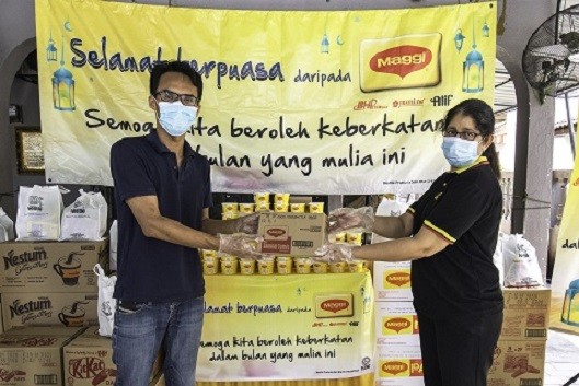 Business Executive Officer of MAGGI®, Nestlé (Malaysia) Berhad, Geetha Balakrishna was distributing MAGGI® bubur lambuk and Nestlé Food and Beverage Packs to Muhammad Afiq bin Md Shahid, Manager of Rumah Jagaan As Samad